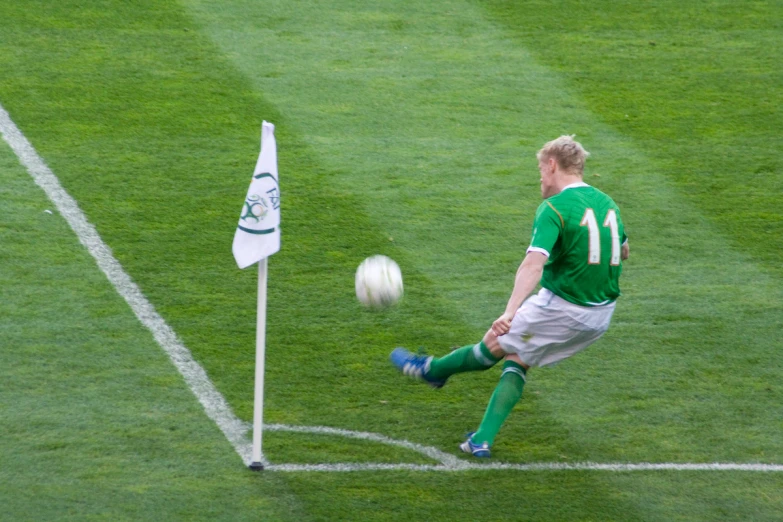 a soccer player kicking the ball across the field
