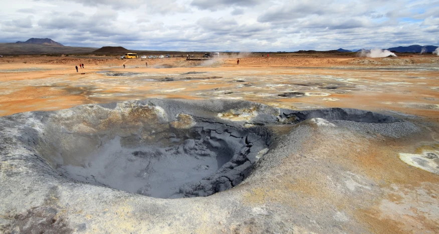 people standing at the base of a large crater