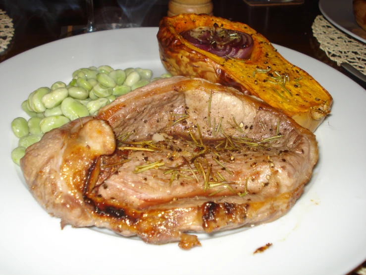 the plate is covered with meat, beans and potatoes