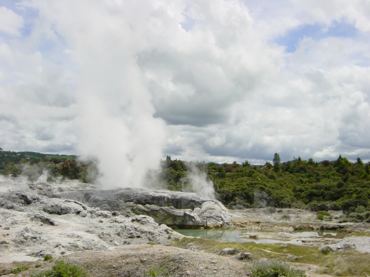 steam pouring out of the ground onto a forest and land