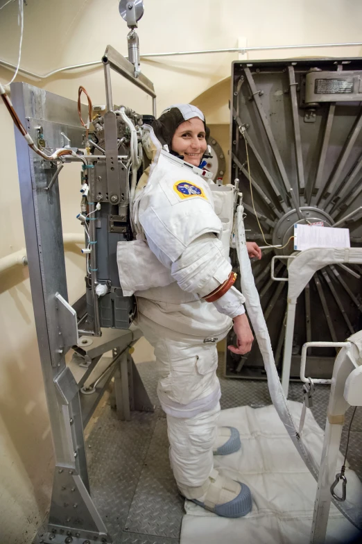 a woman in an astronaut suit leaning against the side of a machine