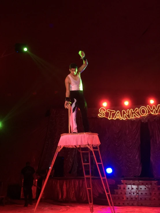 a man on top of a ladder with an apple in his hand