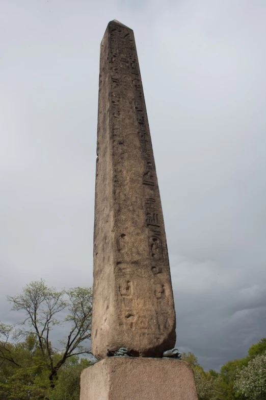 a monument with writing on it in front of trees