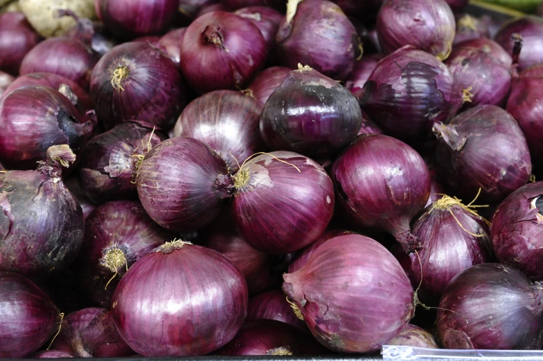 pile of red onions sit next to each other