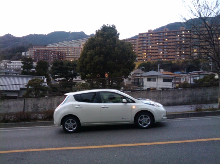 small electric car driving down road near residential area