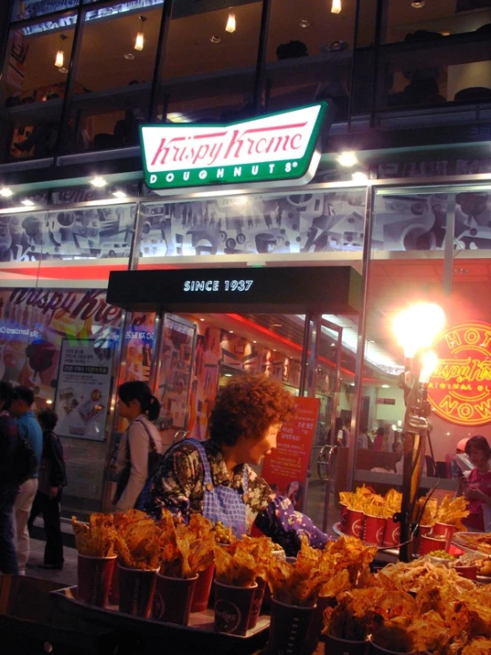 two women standing in front of a doughnut shop