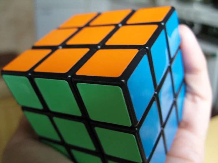 a person is holding a colorful cube in their hand