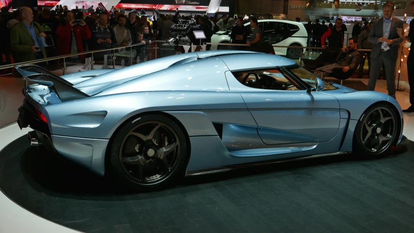 this blue and white sports car sits on display