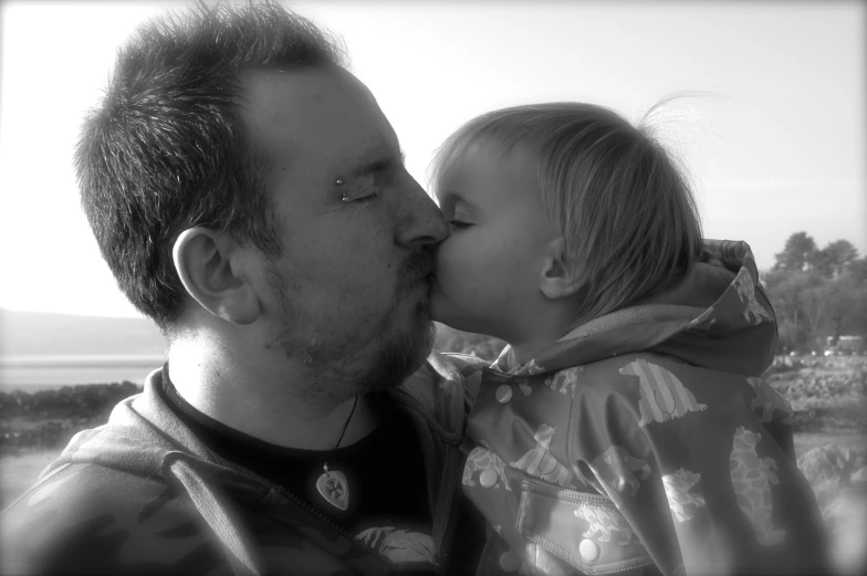 a man and a young child who is kissing