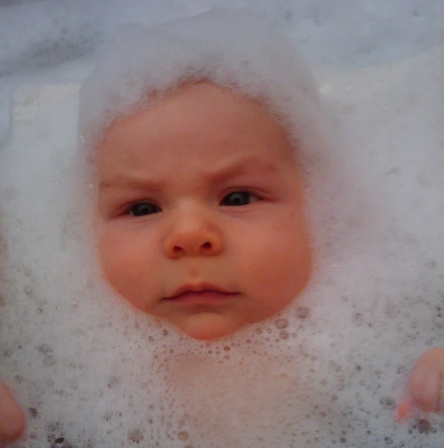 there is a baby laying in a bath tub