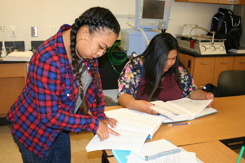 two girls standing in front of an open book