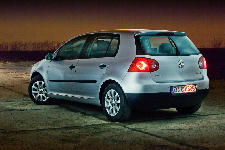 a silver car parked in front of a black car