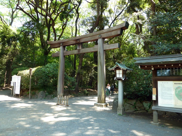 a wooden arch surrounded by lush vegetation and a signboard