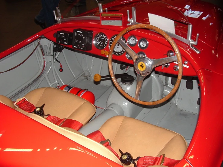 a red car is parked in a showroom