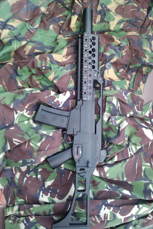 an ak47 rifle laying on camouflage fabric