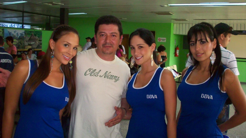 four young women standing around a man wearing blue dress shirts