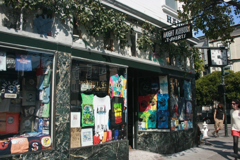 a woman is walking down a sidewalk past an art shop