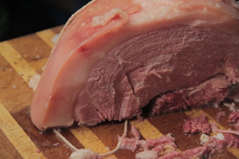 a knife slicing meat into pieces on a  board