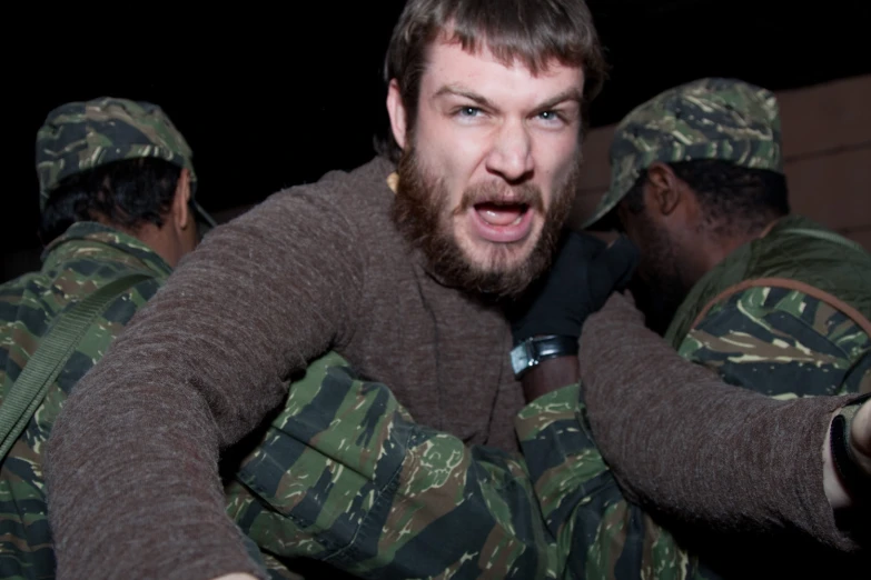 a man in camouflage shirt with a camera around him