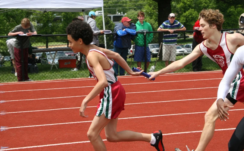 two people are walking on a track with one person reaching out to their other