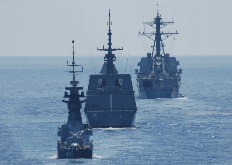 a row of ships in the ocean near each other