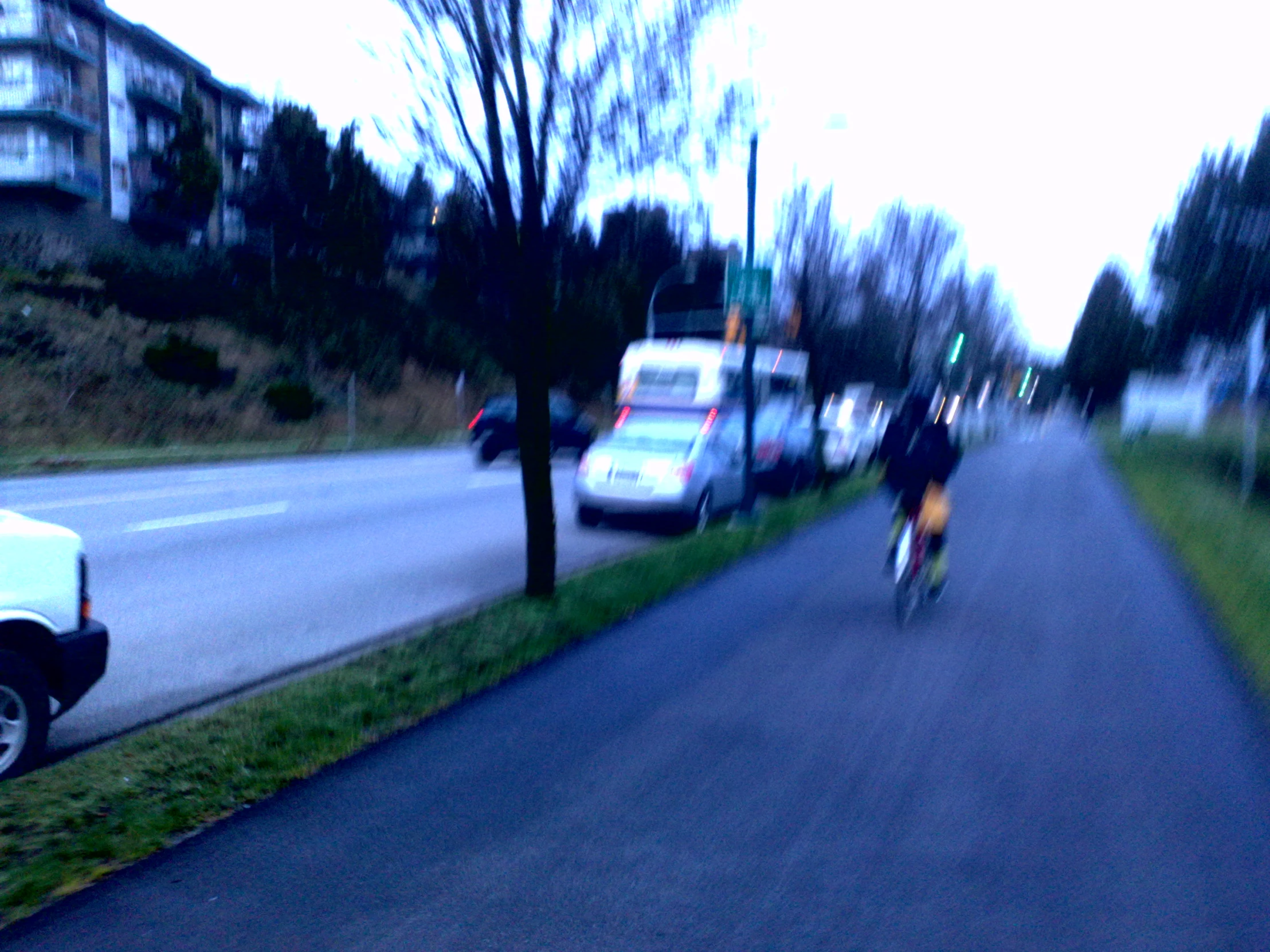 bicyclist riding through urban neighborhood near roadway