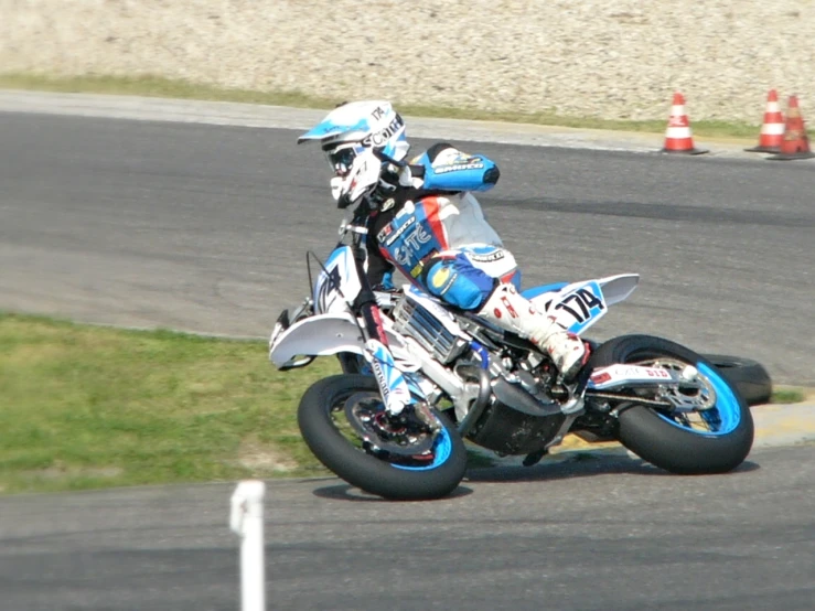 motorcycle racing going on the racetrack with the rider leaning into turn