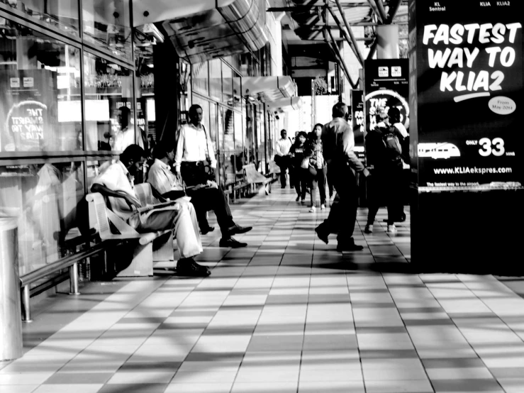 several people sitting on a bench in a subway station