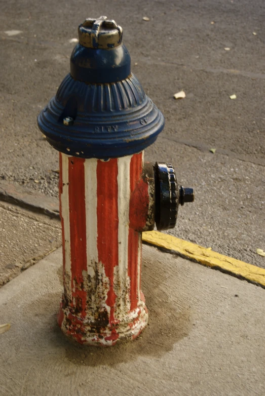 a fire hydrant painted red, white and blue with stripes