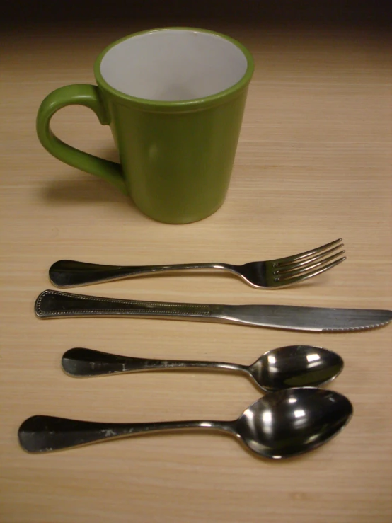 a spoon, fork and cup on the counter