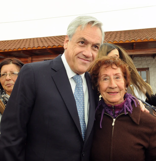 an old woman and an older man stand next to each other