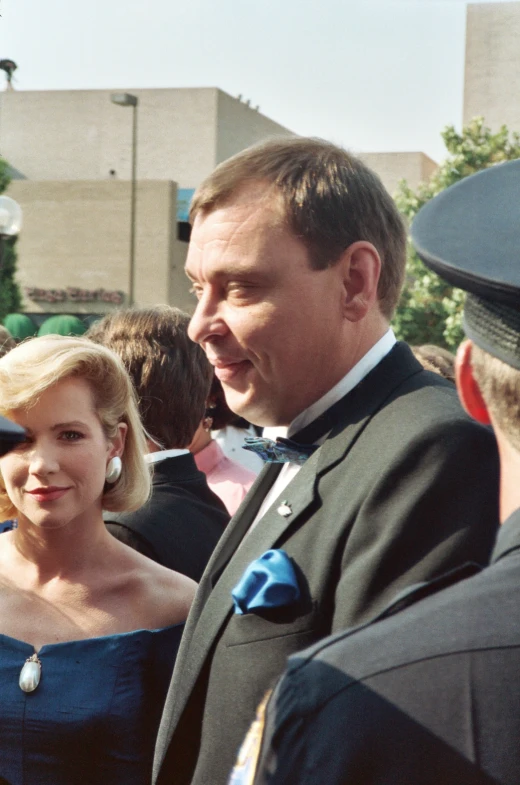 a young man and woman in formal clothing standing together