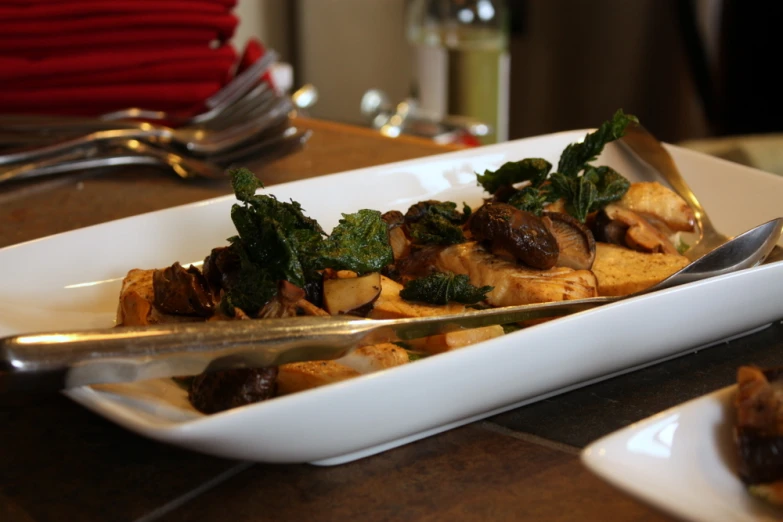 food on a white plate with silverware in front of it