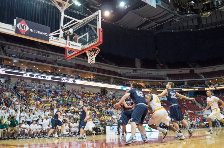 basketball players in action in front of a crowd