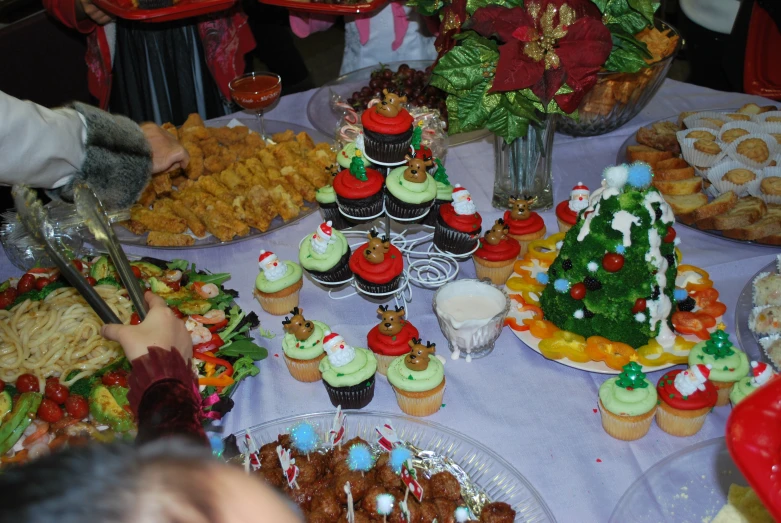 a bunch of decorated cup cakes and muffins sitting on a table