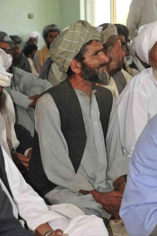 men are sitting on the ground while one stands