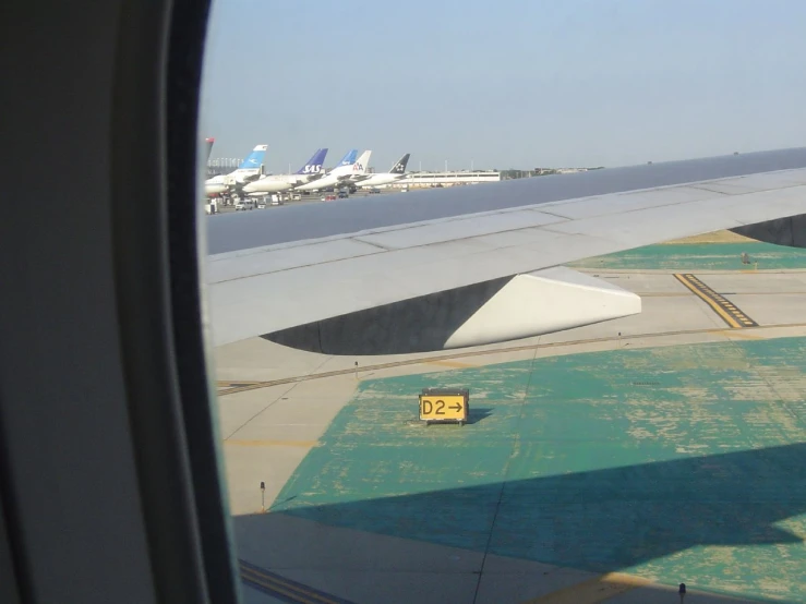 view from an airplane window overlooking a line of parked planes