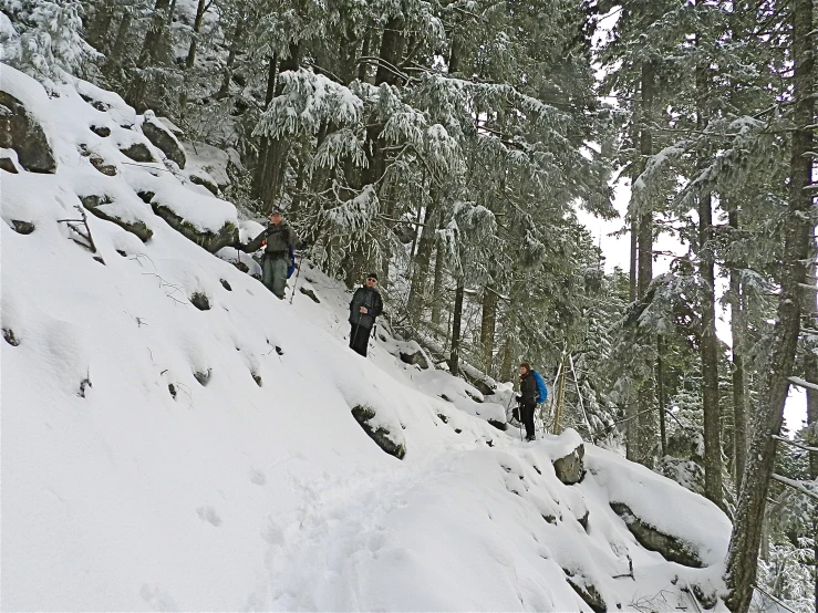 a line of people ski up the side of a snowy mountain