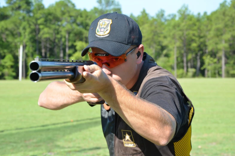 a man is wearing goggles, a hat and holding a revolver