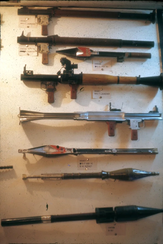 a wall mounted display of various hunting rifles
