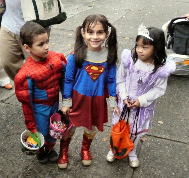 three children on a street posing for the camera