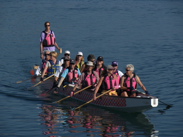 a boat with people wearing life jackets rows down the river