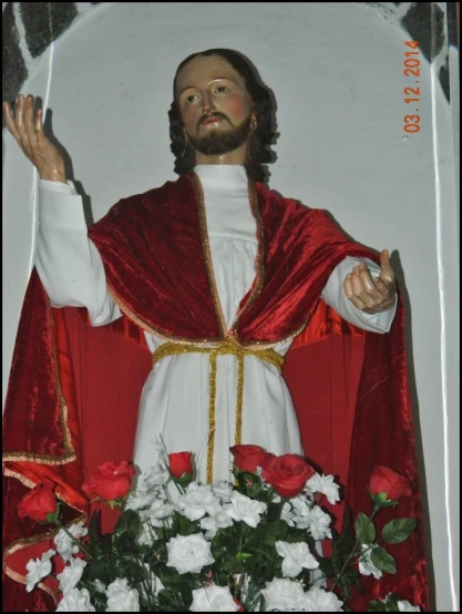 a statue of jesus on display next to a bouquet