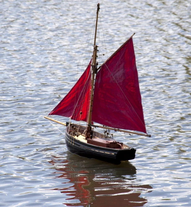 a boat with sails is floating on the water