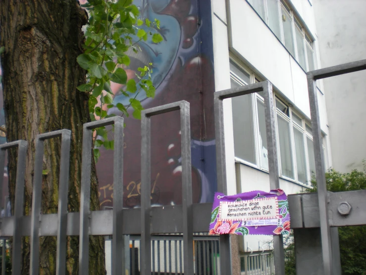 a fence is beside a tall building with a colorful wall