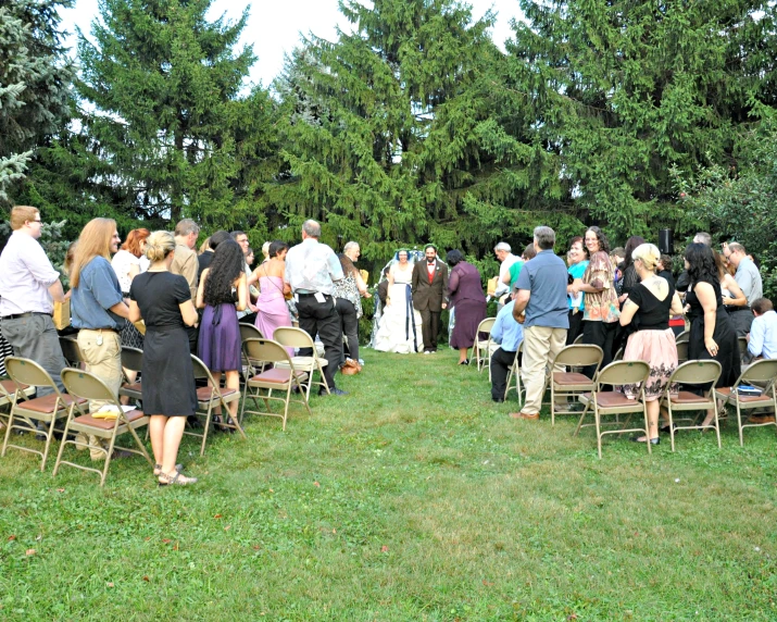 a group of people standing around in the grass