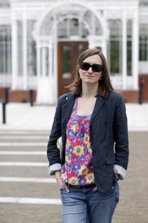 a woman in a jacket is standing on brick