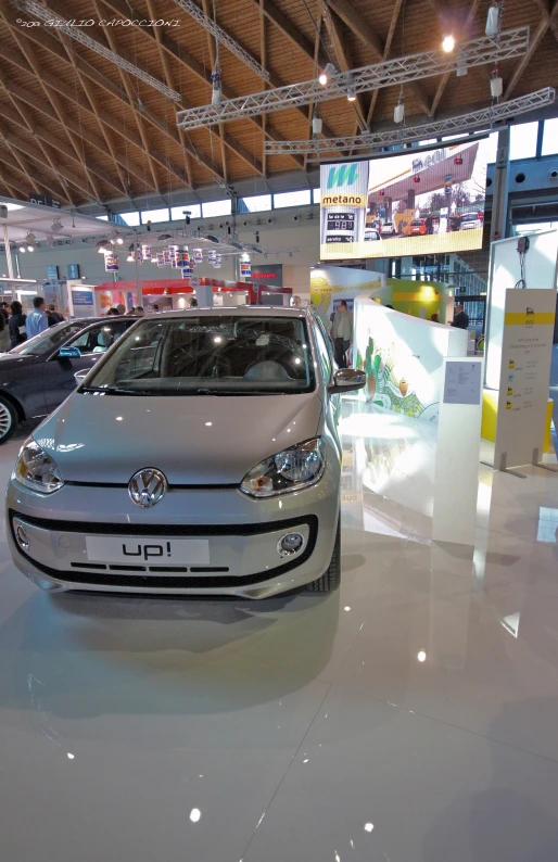 silver compact car in the center of a showroom