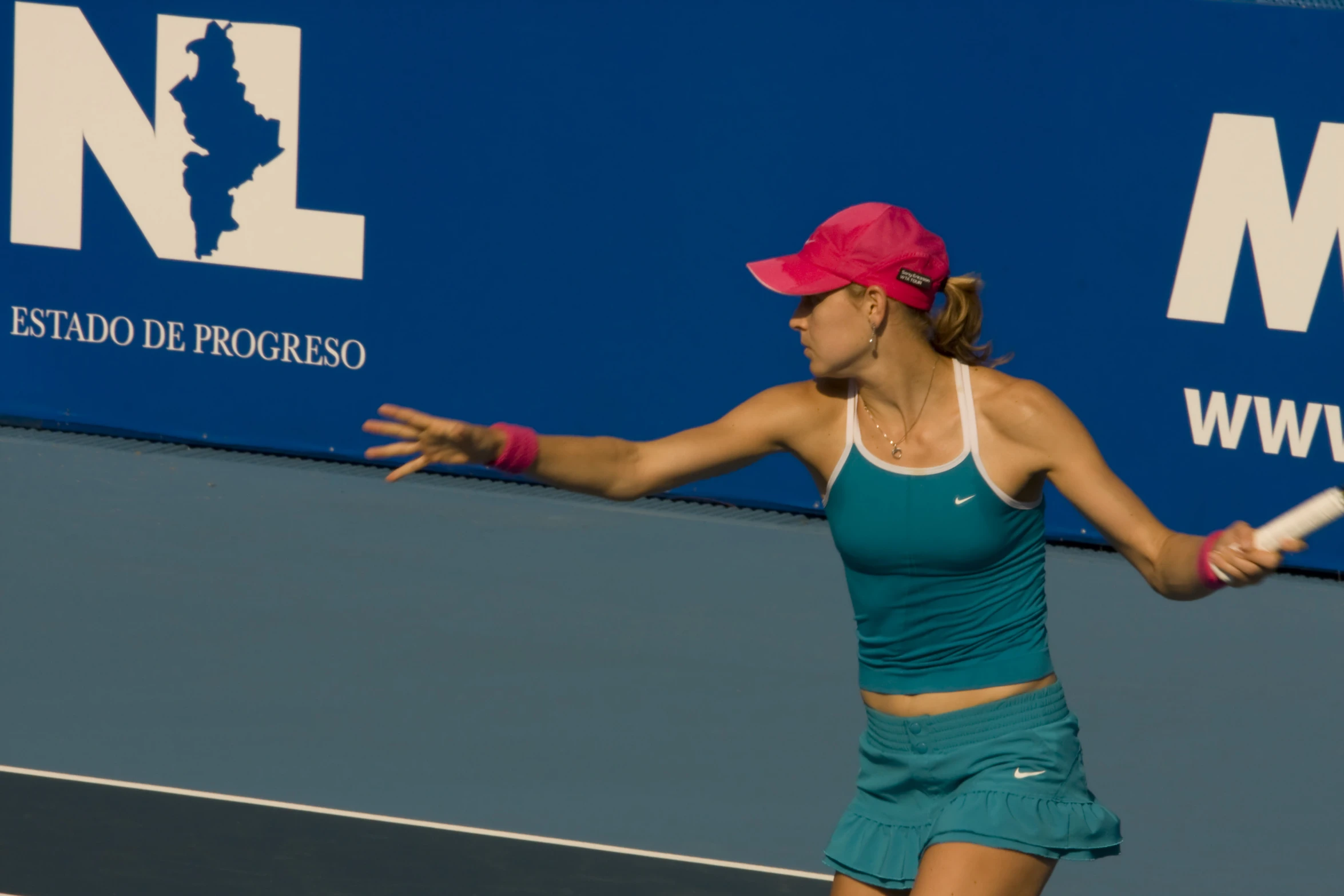 a woman standing on a tennis court holding a racquet