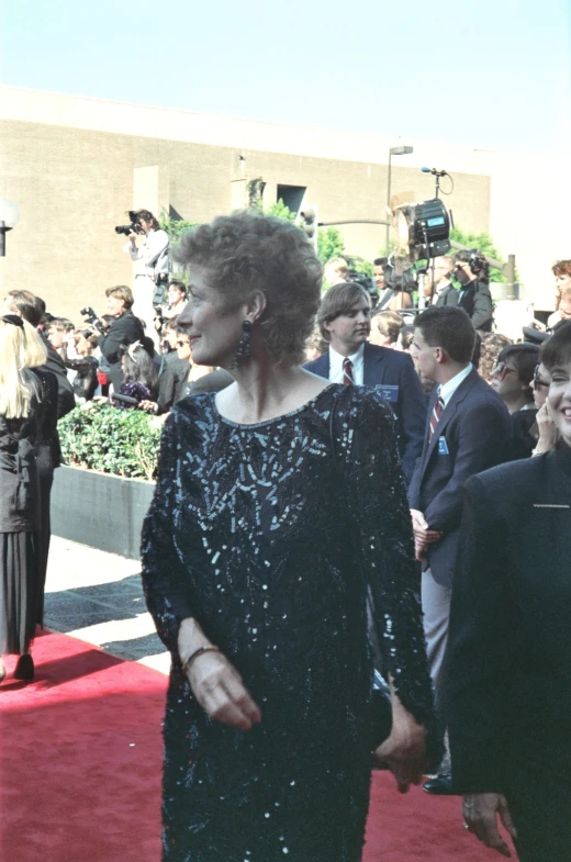 a woman wearing a black dress and looking off to the side